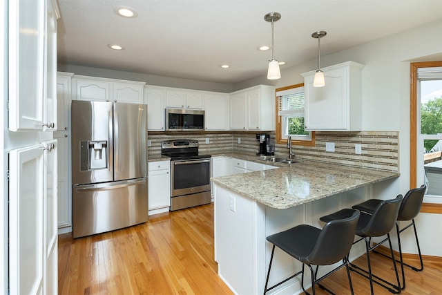 5525 SE 29th Ct, Des Moines, IA 50320 - kitchen with stainless steel appliances, a peninsula, a sink, healthy amount of natural light, and recessed lighting