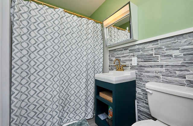 623 W Front St, Stuart, IA 50250 - bathroom with toilet, vanity, and tile walls