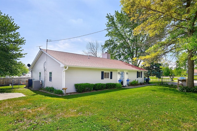 623 W Front St, Stuart, IA 50250 - rear view of property featuring central air condition unit and a chimney
