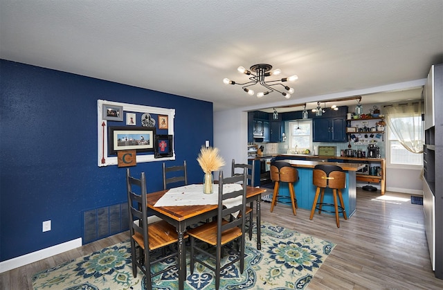 623 W Front St, Stuart, IA 50250 - dining room with a chandelier, wood finished floors, and baseboards