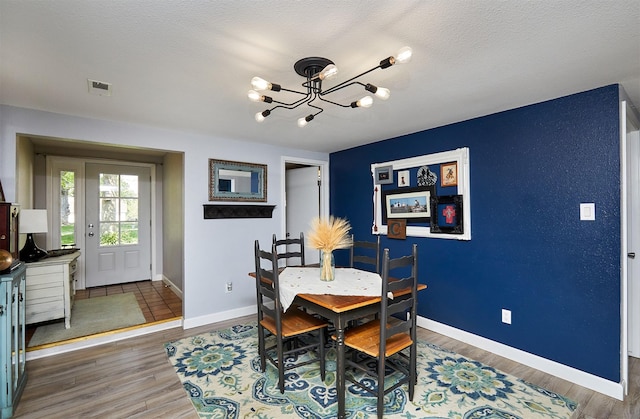 623 W Front St, Stuart, IA 50250 - dining room with a chandelier, baseboards, and wood finished floors