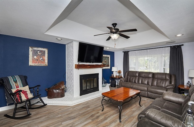 623 W Front St, Stuart, IA 50250 - living room with a raised ceiling, ceiling fan, wood finished floors, and a fireplace