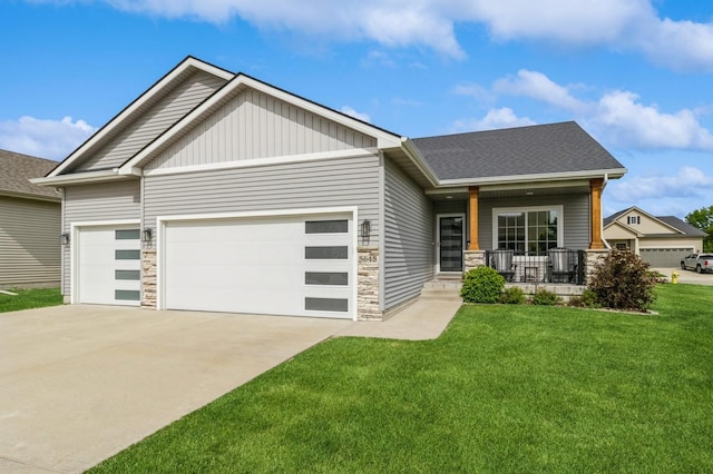 5645 Prairie Grass Dr, Johnston, IA 50131 - craftsman-style house featuring an attached garage, stone siding, covered porch, and concrete driveway
