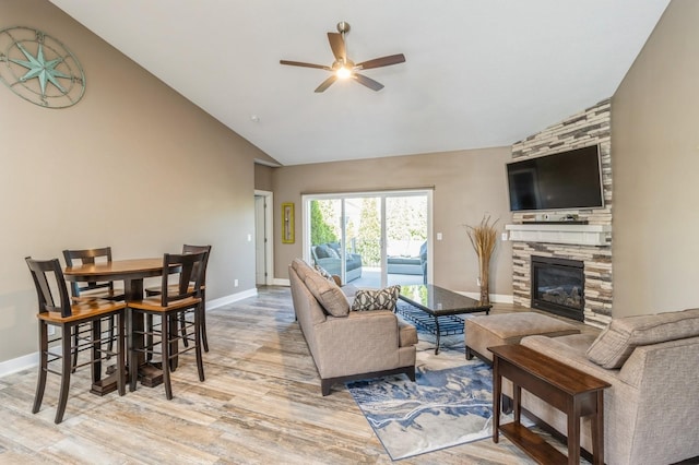 5645 Prairie Grass Dr, Johnston, IA 50131 - living room featuring ceiling fan, wood finished floors, a stone fireplace, high vaulted ceiling, and baseboards
