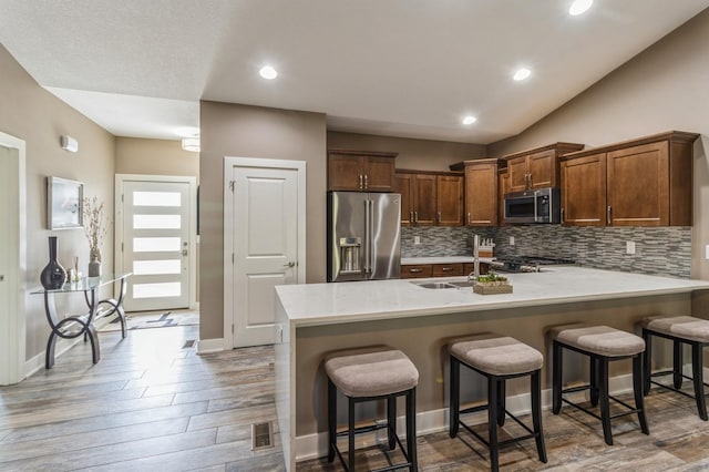 5645 Prairie Grass Dr, Johnston, IA 50131 - kitchen featuring stainless steel appliances, light countertops, tasteful backsplash, a peninsula, and wood finished floors