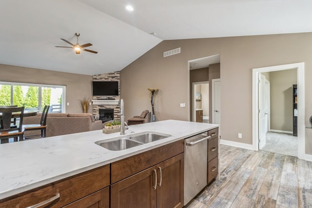 5645 Prairie Grass Dr, Johnston, IA 50131 - kitchen featuring dishwasher, a sink, ceiling fan, vaulted ceiling, and light wood finished floors
