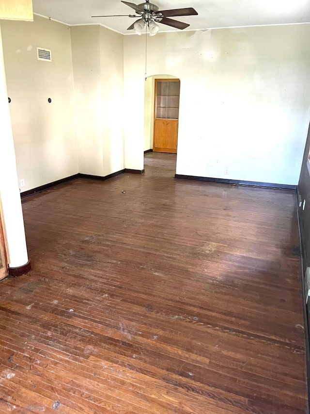 1216 Marshall St, Boone, IA 50036 - unfurnished room featuring ceiling fan, dark wood-style floors, baseboards, and arched walkways