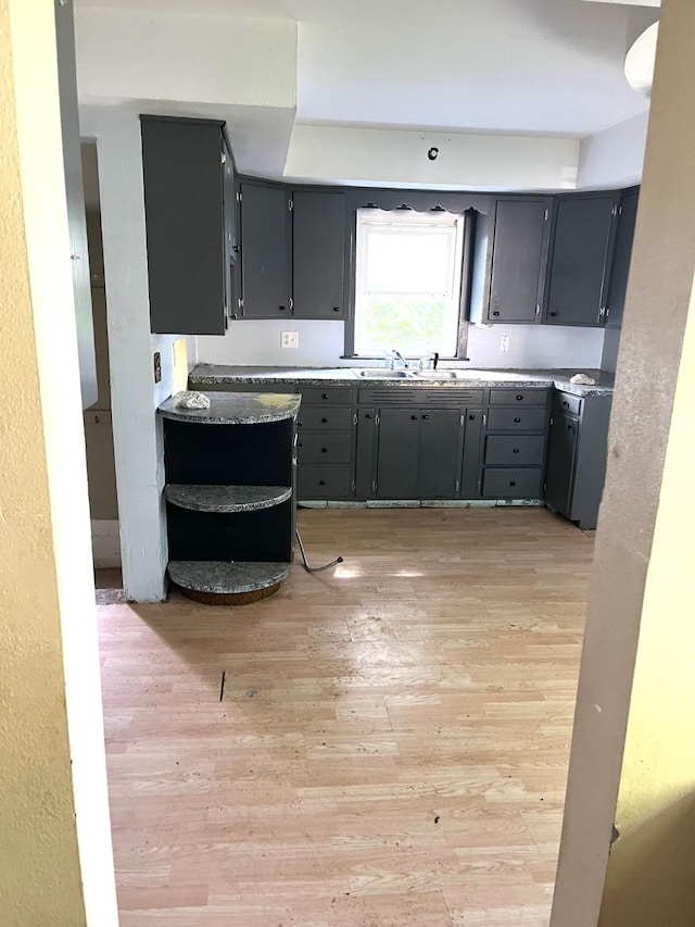 1216 Marshall St, Boone, IA 50036 - kitchen featuring light wood finished floors, gray cabinets, open shelves, and a sink