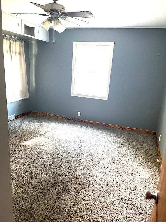 1216 Marshall St, Boone, IA 50036 - carpeted empty room with healthy amount of natural light, a ceiling fan, and baseboards