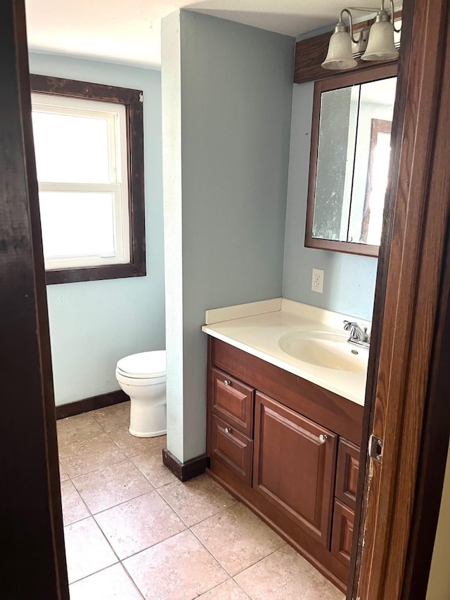 1216 Marshall St, Boone, IA 50036 - bathroom featuring vanity, toilet, tile patterned flooring, and baseboards