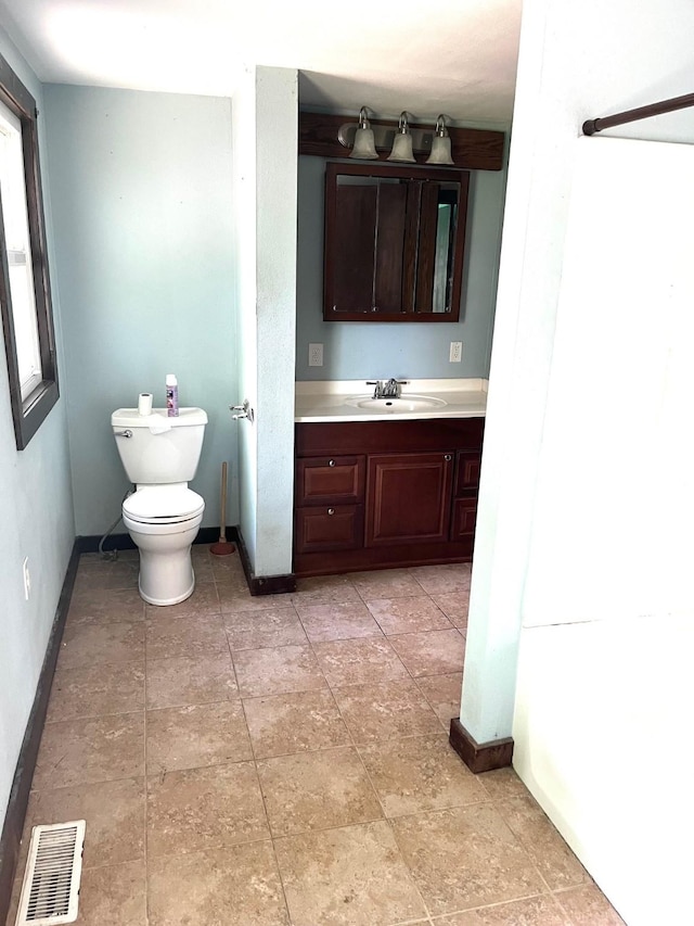 1216 Marshall St, Boone, IA 50036 - bathroom featuring vanity, toilet, and baseboards
