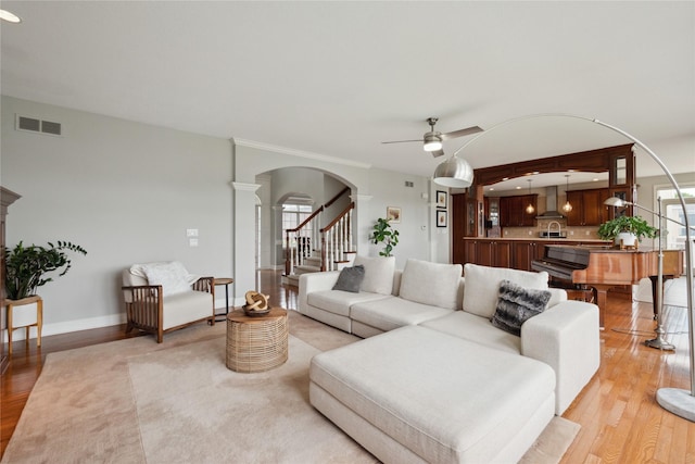 3322 Harrison Rd, Ames, IA 50010 - living area featuring light wood finished floors, arched walkways, a ceiling fan, stairs, and baseboards
