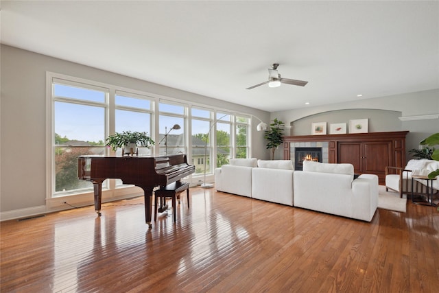 3322 Harrison Rd, Ames, IA 50010 - living room with wood finished floors, a ceiling fan, a tile fireplace, recessed lighting, and baseboards