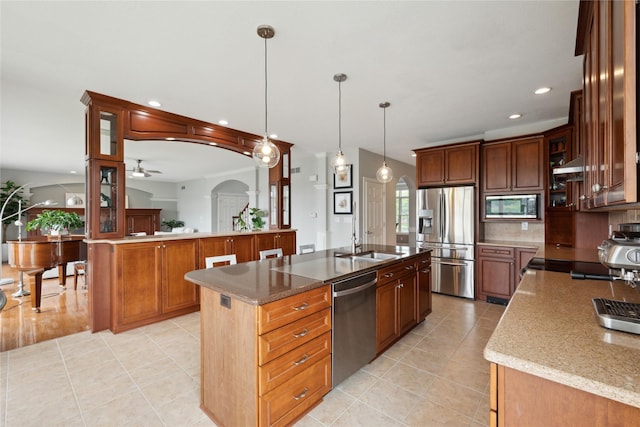 3322 Harrison Rd, Ames, IA 50010 - kitchen with stainless steel appliances, arched walkways, recessed lighting, a center island with sink, and light tile patterned floors