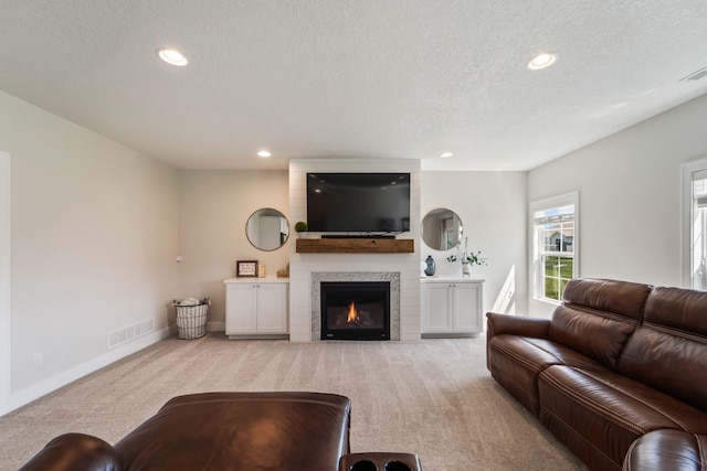 901 Cardinal Dr, Polk City, IA 50226 - living area with light colored carpet, a textured ceiling, a large fireplace, recessed lighting, and baseboards
