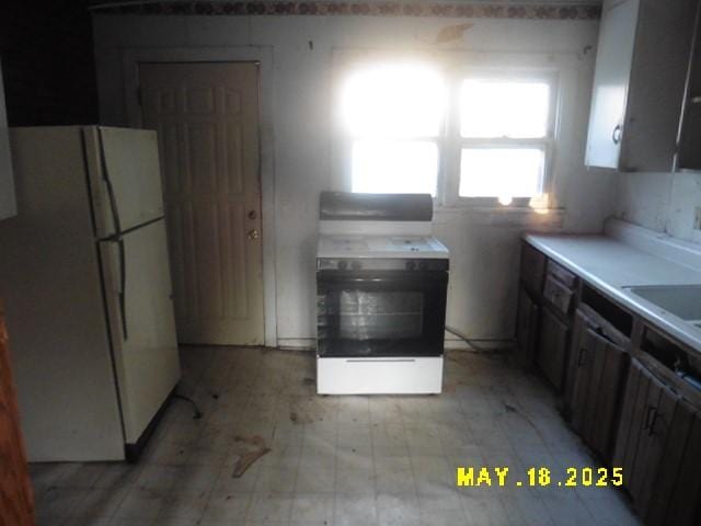 206 S D St, Indianola, IA 50125 - kitchen featuring freestanding refrigerator, range, and light countertops