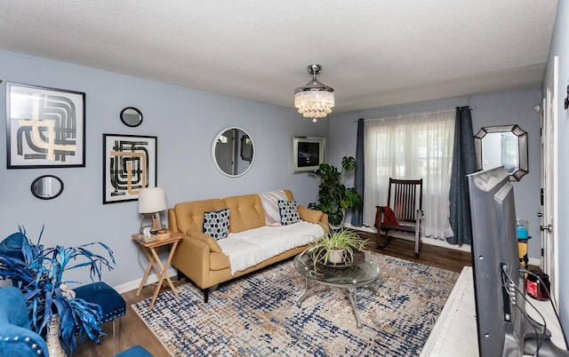 1309 Mccormick St, Des Moines, IA 50316 - living area featuring wood finished floors, a chandelier, baseboards, and a textured ceiling