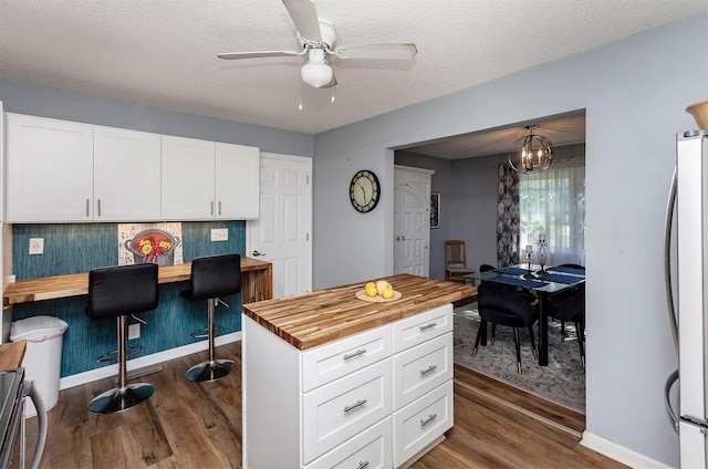 1309 Mccormick St, Des Moines, IA 50316 - kitchen featuring wooden counters, freestanding refrigerator, dark wood-style floors, a ceiling fan, and a textured ceiling