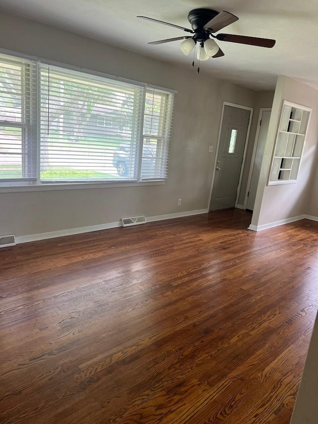 160 Bel Aire Dr, Waukee, IA 50263 - unfurnished living room with ceiling fan, plenty of natural light, dark wood-style flooring, and baseboards