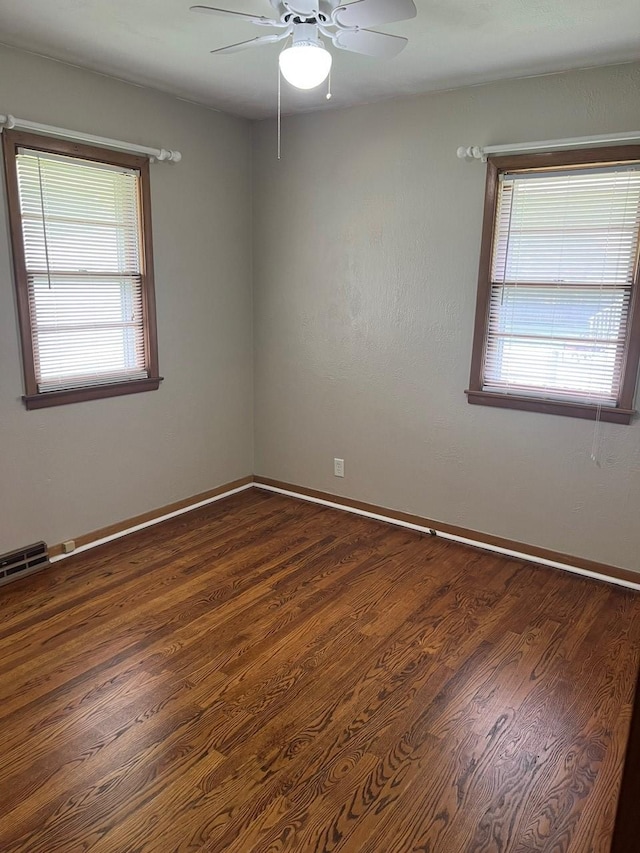 160 Bel Aire Dr, Waukee, IA 50263 - empty room featuring plenty of natural light, a ceiling fan, dark wood-style floors, and baseboards