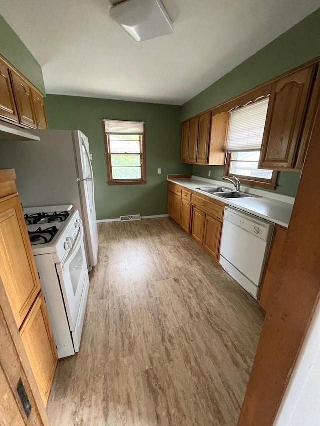160 Bel Aire Dr, Waukee, IA 50263 - kitchen with white appliances, a sink, light wood-type flooring, and plenty of natural light