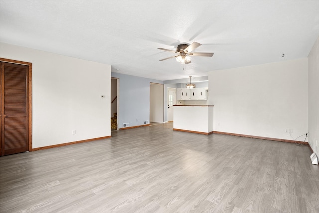 807 Center St, Grinnell, IA 50112 - unfurnished living room featuring a ceiling fan, light wood-style flooring, baseboards, and stairway