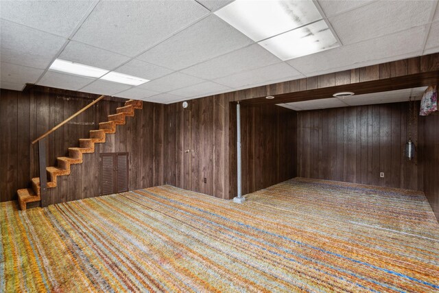 807 Center St, Grinnell, IA 50112 - finished basement with stairway, carpet floors, wooden walls, and a drop ceiling