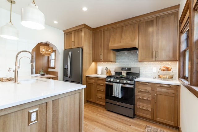 6704 Elmcrest Dr, Windsor Heights, IA 50324 - kitchen featuring stainless steel appliances, custom range hood, a sink, arched walkways, and backsplash