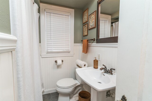 6704 Elmcrest Dr, Windsor Heights, IA 50324 - bathroom featuring toilet, wainscoting, tile patterned flooring, a shower with shower curtain, and a sink