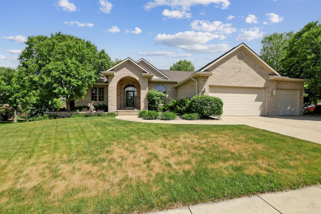 3201 Foxley Dr, Ames, IA 50010 - view of front of home featuring an attached garage, concrete driveway, brick siding, and a front yard
