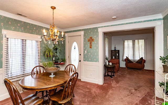 113 N Locust St, Madrid, IA 50156 - carpeted dining area featuring crown molding, a chandelier, wallpapered walls, a wainscoted wall, and a textured ceiling