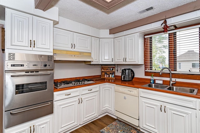 113 N Locust St, Madrid, IA 50156 - kitchen with appliances with stainless steel finishes, a warming drawer, a sink, a textured ceiling, and dark wood-type flooring