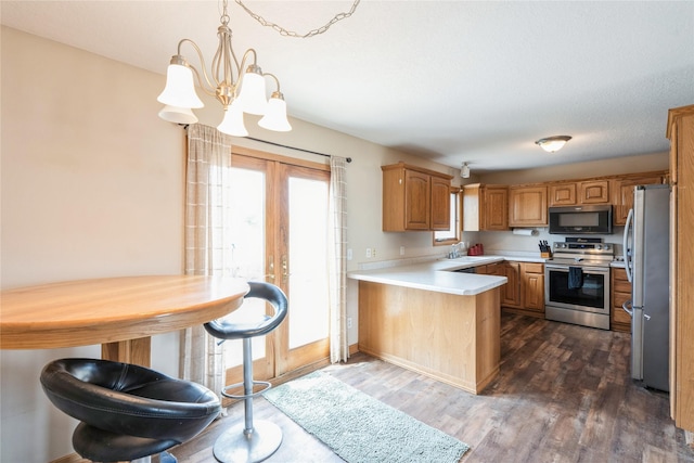 5545 E Douglas Ave, Des Moines, IA 50317 - kitchen with stainless steel appliances, a sink, a peninsula, dark wood-style flooring, and light countertops
