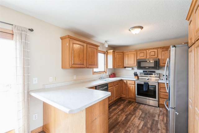 5545 E Douglas Ave, Des Moines, IA 50317 - kitchen with appliances with stainless steel finishes, a peninsula, dark wood finished floors, a sink, and light countertops