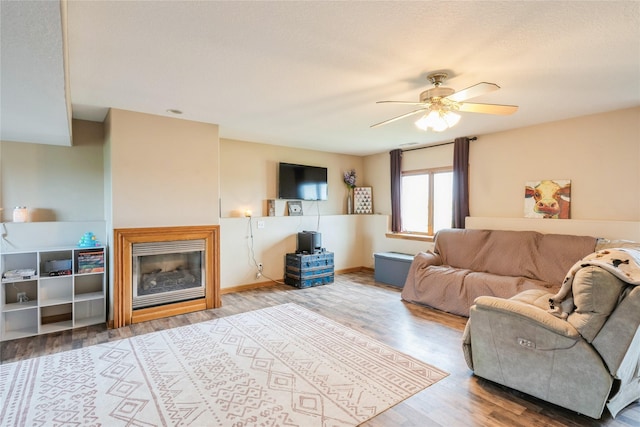 5545 E Douglas Ave, Des Moines, IA 50317 - living room featuring wood finished floors, ceiling fan, and a glass covered fireplace