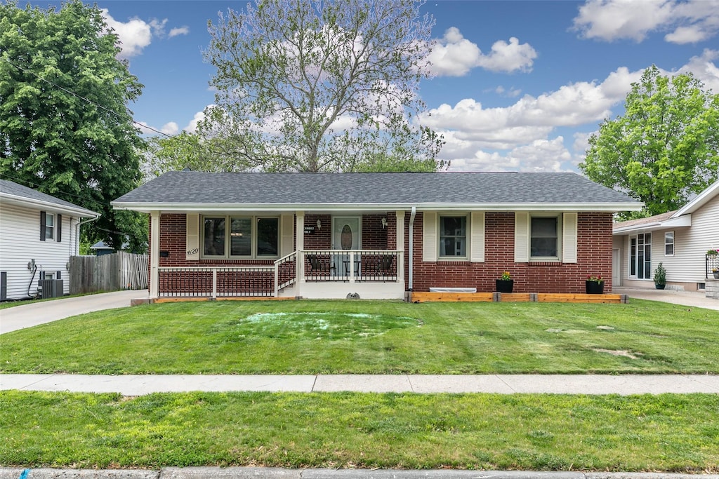 4120 65th St, Urbandale, IA 50322 - view of front of house featuring a porch, brick siding, central AC unit, and a shingled roof