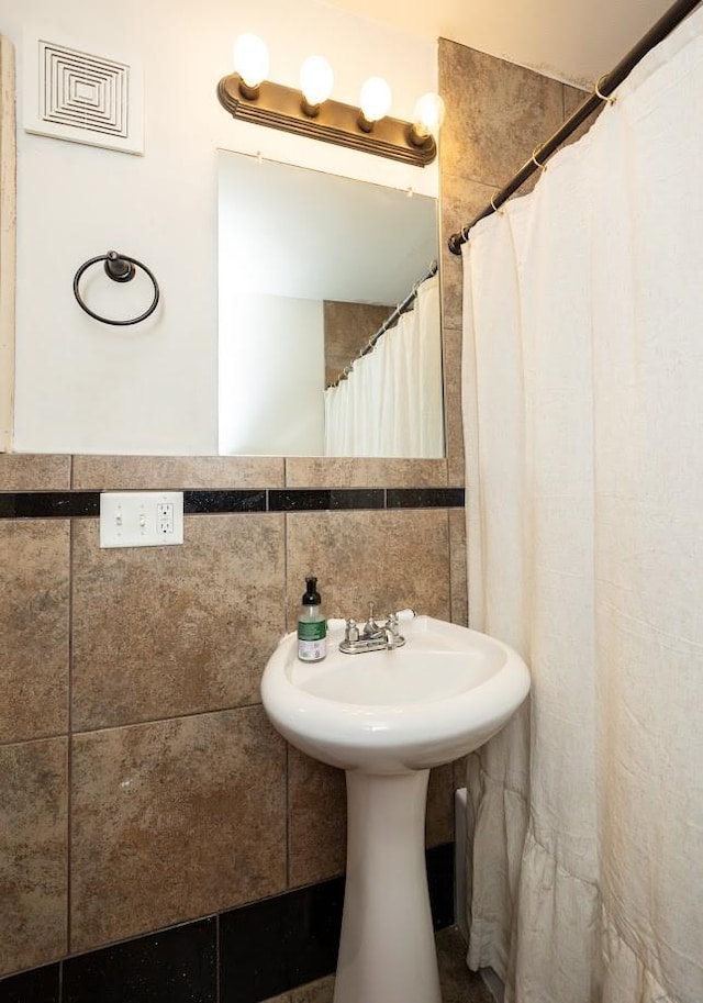 2004 40th St, Des Moines, IA 50310 - full bathroom featuring tile walls and a sink