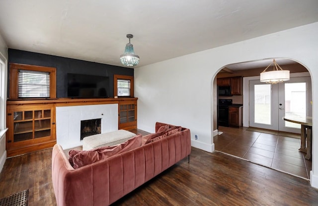 2004 40th St, Des Moines, IA 50310 - living area with arched walkways, a premium fireplace, baseboards, and dark wood-style floors