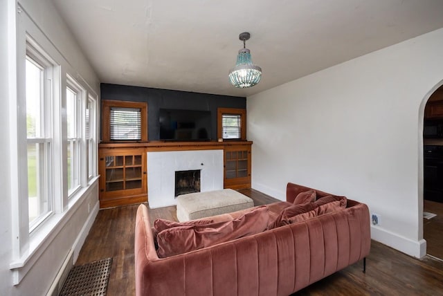 2004 40th St, Des Moines, IA 50310 - living room with healthy amount of natural light, arched walkways, dark wood-style floors, and a fireplace