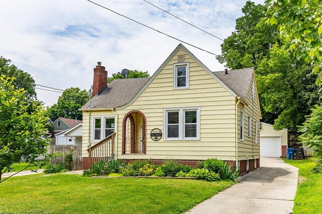 2004 40th St, Des Moines, IA 50310 - view of front of house with a chimney, an outbuilding, roof with shingles, and a garage