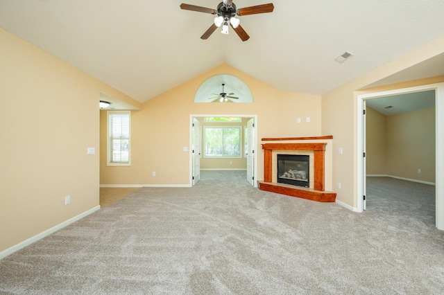3305 SE Glenstone Dr Unit 236, Grimes, IA 50111 - unfurnished living room featuring a ceiling fan, carpet flooring, a glass covered fireplace, vaulted ceiling, and baseboards