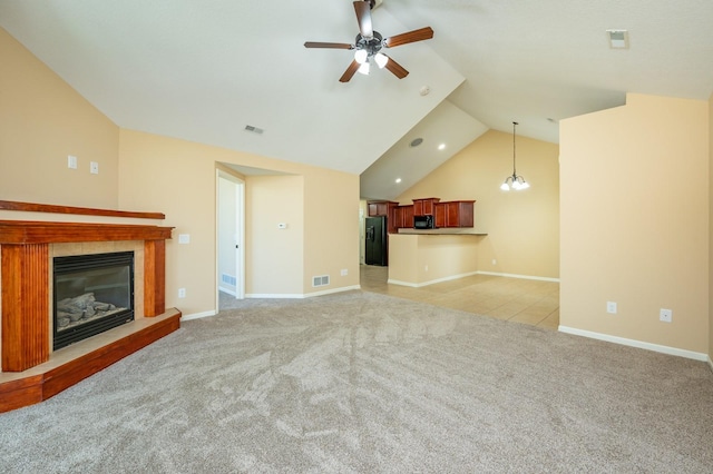 3305 SE Glenstone Dr Unit 236, Grimes, IA 50111 - unfurnished living room featuring a ceiling fan, light colored carpet, a tile fireplace, lofted ceiling, and baseboards