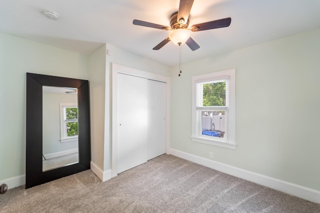 1516 57th Pl, Des Moines, IA 50311 - unfurnished bedroom featuring carpet, multiple windows, and a closet