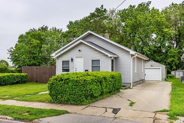 1410 E 21st St, Des Moines, IA 50317 - view of front facade with an outdoor structure, concrete driveway, a detached garage, central AC, and a chimney