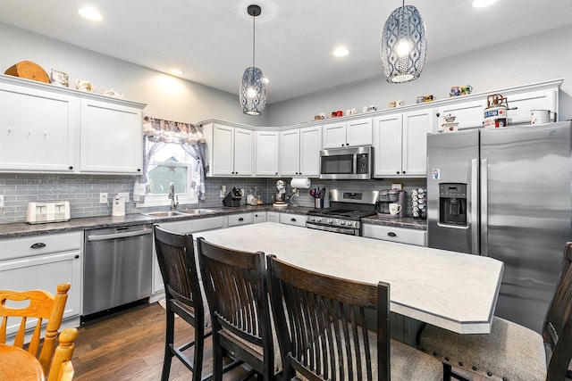 305 E State St, Baxter, IA 50028 - kitchen with stainless steel appliances, a kitchen breakfast bar, decorative backsplash, hanging light fixtures, and recessed lighting