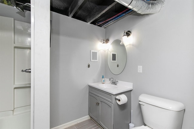 305 E State St, Baxter, IA 50028 - bathroom featuring vanity, toilet, and baseboards