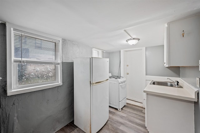732 19th St, Des Moines, IA 50314 - kitchen featuring white appliances, a sink, light wood-style floors, and light countertops