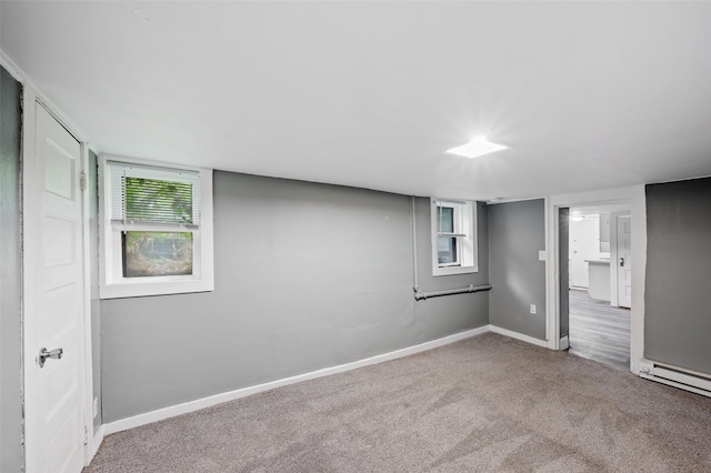 732 19th St, Des Moines, IA 50314 - below grade area with carpet flooring, baseboards, healthy amount of natural light, and a baseboard radiator