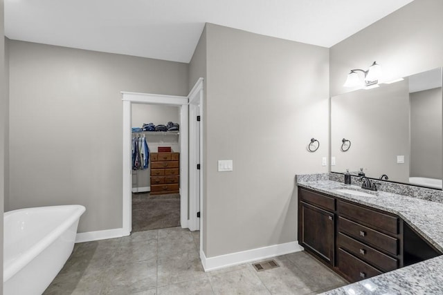3911 NW 14th Ct, Ankeny, IA 50023 - full bath with a freestanding tub, vanity, a walk in closet, and baseboards