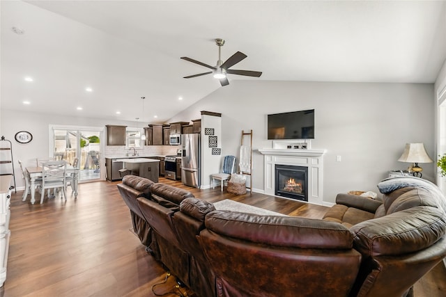 2320 SE Maxwell Dr, Waukee, IA 50263 - living room with ceiling fan, vaulted ceiling, dark wood finished floors, a glass covered fireplace, and recessed lighting